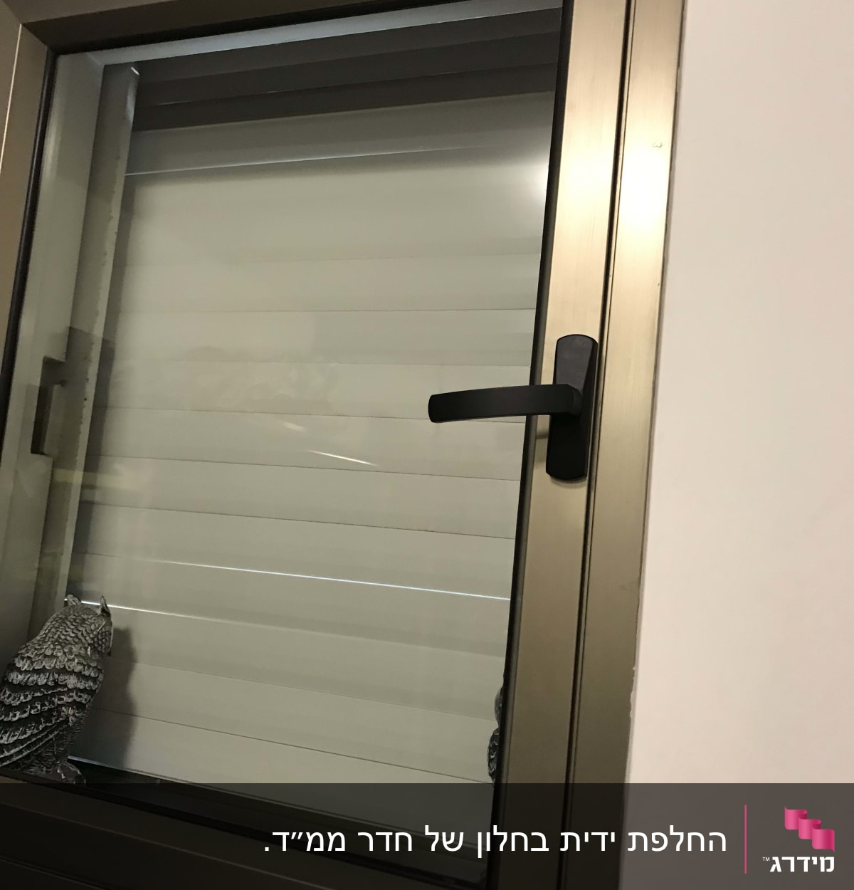 חלון עם תריסים סגורים וידית שחורה